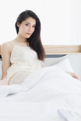 Obraz na płótnie Canvas Asian woman model sitting and posing on bed..