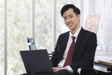 Asian Businessman using laptop in office..