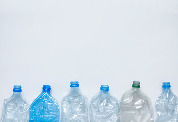 Plastic empty bottles on white background. View from above. Waste recycling concept. Your text place.