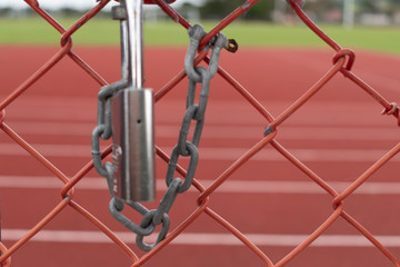 Silver lock and chain on metal fence