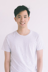 Young Asian man model in T-shirt crossed arm..