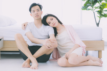 Fototapeta na wymiar Sexy couple in pajamas sit on floor in bedroom..
