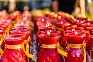 Several rows of red buddhist prayer candles fading into the background