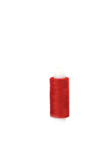 Cotton red threads on the plastic sleeve for the sewing machine.