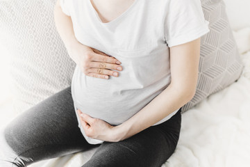 Young pregnant woman touching her belly