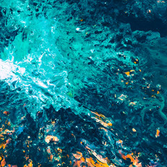 Abstract art texture background. Light reflection on sea surface. Teal blue, white and orange paint mixture splash.