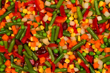 Sliced vegetables, corn, beans, peas, carrots, sweet peppers background.