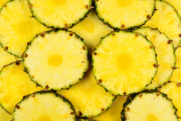 Pineapple juicy yellow slices background. Top view.