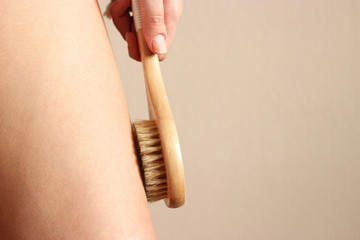 girl uses a natural bristle massage brush at home. Cellulite prevention, skin care