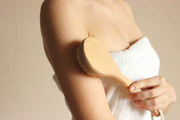 girl uses a natural bristle massage brush at home. Cellulite prevention, skin care