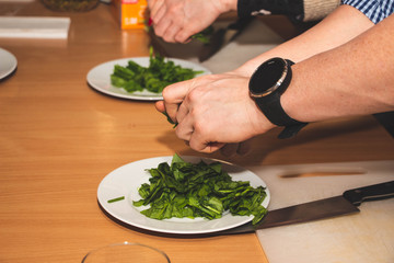  Cooking by hands of people in a group on the table with white dishes