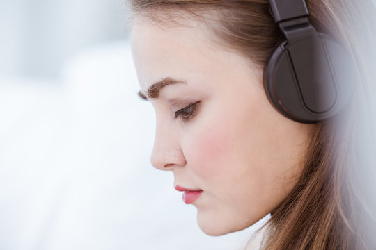 closeup beautiful woman portrait attend to listening music wearing wireless headphone seriously mood