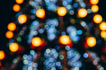 Christmas tree blurred. blurred background of Christmas lights. A new year tree decorated with lanterns is blurred in bokeh. blue and yellow bokeh