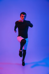 Fototapeta na wymiar Full length portrait of a fit sportsman running isolated