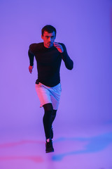Fototapeta na wymiar Full length portrait of a fit sportsman running isolated