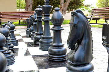 Сhessboard with large plastic figures. Large outdoor chess in the public area, Large street chess in the park