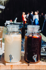 Two large glass bottles of lemonade and wine at a wedding