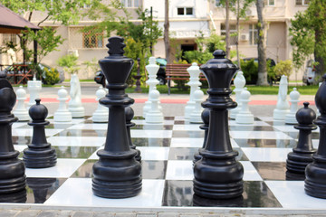 Сhessboard with large plastic figures. Large outdoor chess in the public area, Large street chess in the park