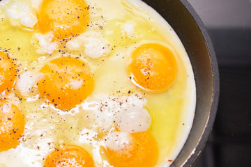 Fried eggs are cooked in a pan on the stove
