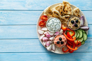 Selection of traditional greek food - salad, meze, pie, fish, tzatziki, dolma on wood background, top view