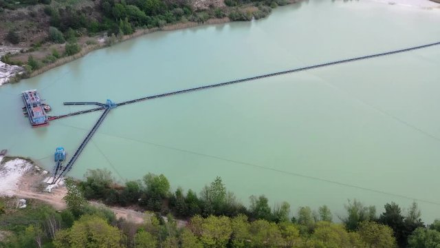 Reverse flight from a mining pond over a country road to the sand fractionator on the shore of a further mining area