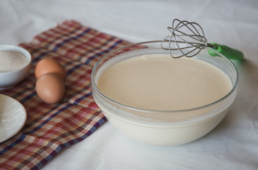 Ready dough for pancakes in a bowl. Home cooking.