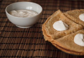Pancakes with cream on the plate. Breakfast.