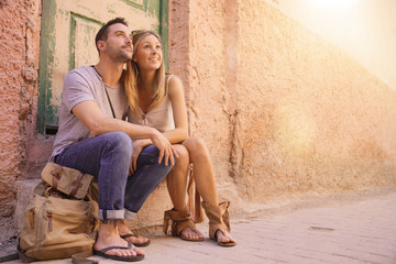 Fototapeta na wymiar Couple of tourists sitting in street of Marrakech