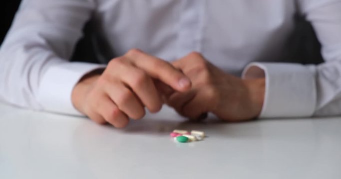 doctor gives a pill to a patient. close-up. the doctor pulls the medicine to the patient. man in white gives a tablet to choose from