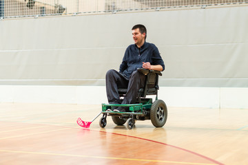 Disabled man on an electric wheelchair playing sports, powerchair hockey. IWAS - International...