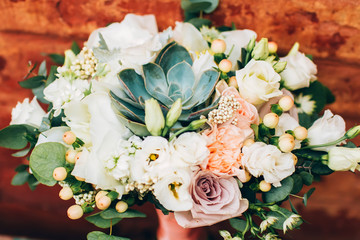 bouquet on the brick wall background. bouquet with peonies and succulents.