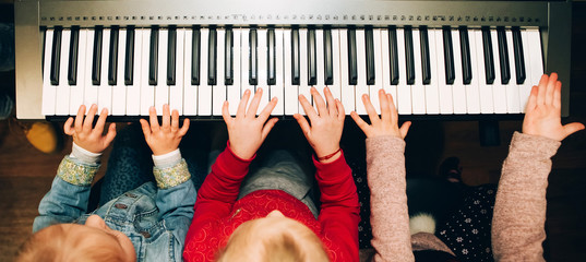 children's hands playing the electric piano. musical instrument in children's hands