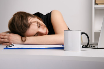 Young businesswoman feeling sleepy at her work place in office