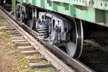 Fototapeta na wymiar Dual gauge track example that allows the passage of trains of two different track gauges narrow-gauge railway and broad-gauge railway with freight wagon