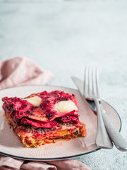 Vegetable Packed Rainbow Lasagne on pink plate. Ideas and recipes for healthy vegetarian dinner or lunch. Lasagne with beetroot, pumpkin, mushrooms, ricotta, spinach, mozarella. Copy space for text.