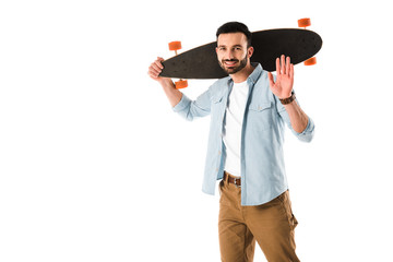 cheerful man with longboard looking at camera and showing hello gesture isolated on white