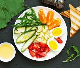 Breakfast and healthy snack of eggs, avocado, cheese and strawberries.