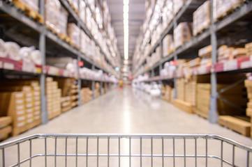Shopping cart view in Warehouse aisle with product shelves abstract blur defocused background