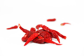 pods of red dried hot bitter edible pepper on a white background