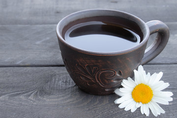 cup of tea with chamomile on an old wooden table. top view with copy space.
