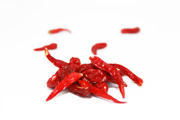 pods of red dried hot bitter edible pepper on a white background