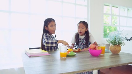 Kid students girls in rush eating breakfast and run to go school, slow motion
