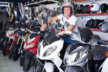 Adult male in helmet is sitting on motorbike