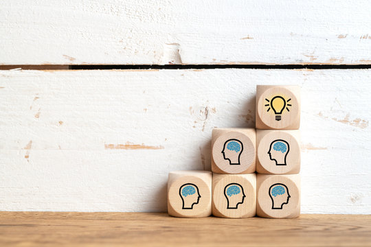     many people together having an idea symbolized by icons on cubes on wooden background 