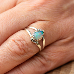 Silver ring with opal gemstone caboshon on female hand