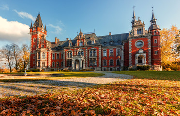 Awesome sunny Landscape, Perfect Sky over the Fairytale castle with Fall Autumn Leafes on foreground. Amazing view on Palace in Plawniowice in Autumn. Upper Silesia, Poland. Crestive image. Postcard
