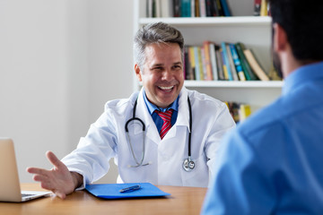 Sympathischer Arzt mit Patient bei der Sprechstunde