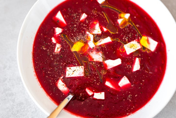 Beetroot soup in white plate on the modern grey texture background