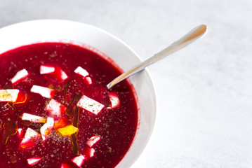 Beetroot soup in white plate on the modern grey texture background
