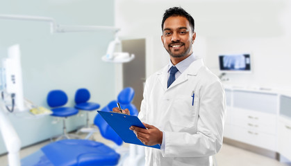 medicine, dentistry and healthcare concept - smiling indian male dentist in white coat with...